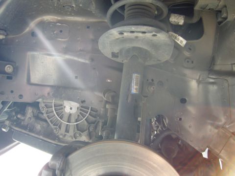 2007 Ford Mustang - Close-up view of a vehicle's undercarriage components, including suspension and transmission.
