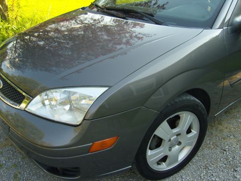 2007 Ford Mustang - The front quarter panel and headlight of a gray Ford Focus are visible.