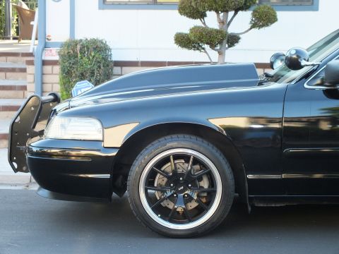2003 Ford Crown Victoria - Detail shot of the lowered sedan's front quarter showing the lip-edge wheel and brush guard mount.