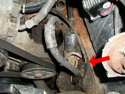 1990 Ford Bronco - Close-up view of engine parts, with a red arrow highlighting a yellow clip.