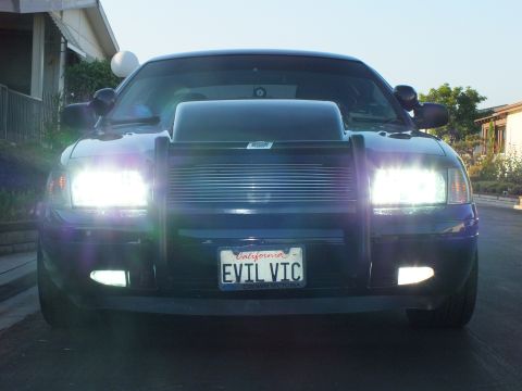 2003 Ford Crown Victoria - Twilight front shot of the lowered sedan, headlights and fog lights fully illuminated.