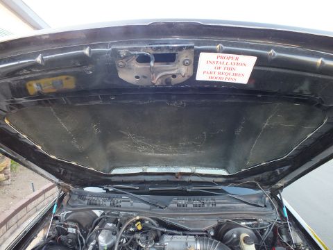 2003 Ford Crown Victoria - Close view beneath the raised hood showing the worn liner and warning sticker over the engine.