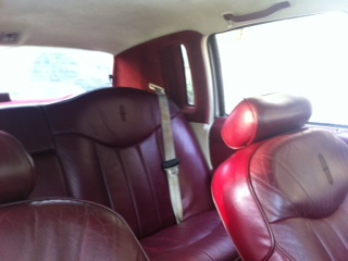 1997 Lincoln Town Car - Interior view of a car's red leather seats and headrests.