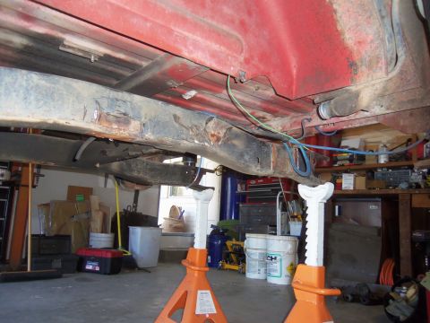 1968 Ford Bronco - The underside of a vehicle is visible, supported by jack stands in a garage setting.