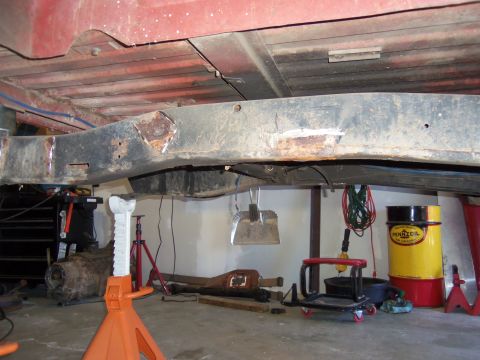 1968 Ford Bronco - The vehicle's frame appears to have undergone modifications, with tools and parts scattered around the garage floor.