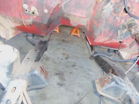 1968 Ford Bronco - The underside of a vehicle's engine bay is visible, supported by jack stands, with exposed frame rails.