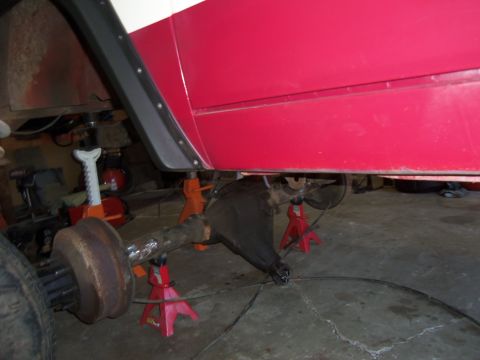 1968 Ford Bronco - Vehicle rear axle assembly supported by jack stands, with body panels visible overhead.
