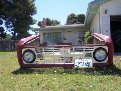 1968 Ford Bronco - The front end of a 1968 Ford Bronco sits on display in a grassy yard in front of a house.