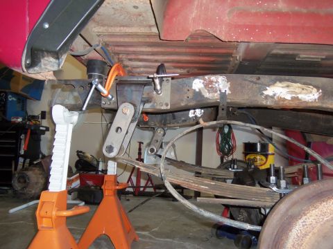 1968 Ford Bronco - Custom suspension modifications are underway on a vehicle's frame, supported by jack stands.