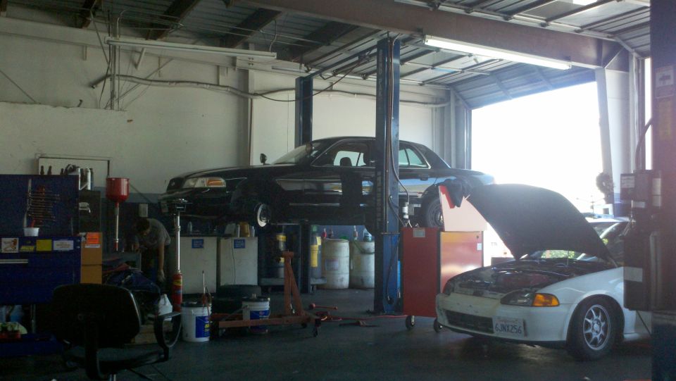Rotated interior view of vehicles on lifts inside an automotive service shop