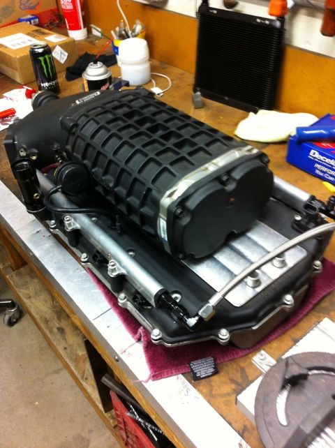 2010 Dodge Challenger - Supercharger assembly on a workbench, likely for a performance vehicle modification.