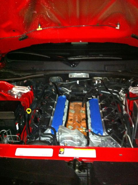 2010 Dodge Challenger - The engine bay of a vehicle is shown with various components and wiring visible under the hood.