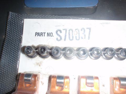2000 Dodge 1500 - Close-up of automotive parts in packaging, including a row of metal components and orange pieces.