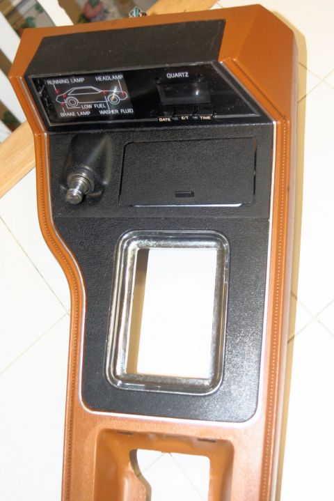 1980 Ford Mustang - Dashboard trim panel displays warning lights and a quartz clock, with a blank space for a radio or other component.