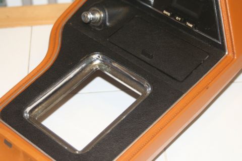 1980 Ford Mustang - Close-up of a vehicle's center console, a chrome-trimmed opening and a digital clock display.