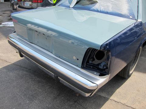 1991 Ford LTD Crown Victoria - A car's rear end is shown with a chrome bumper and a trunk that is partially painted. One taillight housing is empty.