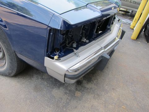 1991 Ford LTD Crown Victoria - The front of a car is shown, with the grille and one headlight missing, revealing internal components.