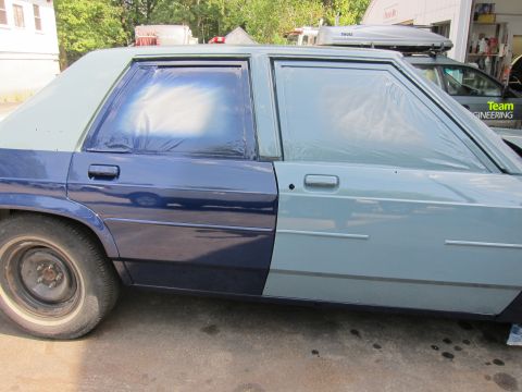 1991 Ford LTD Crown Victoria - Side view of a 1991 Ford Crown Victoria LTD undergoing paintwork, with windows taped off.