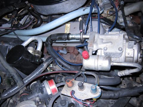 1991 Ford LTD Crown Victoria - Close-up view of the engine bay, highlighting the air conditioning system's compressor and associated plumbing.