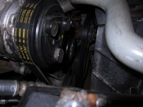 1991 Ford LTD Crown Victoria - A view of the engine's belt-driven components, showing the AC compressor and serpentine belt system.