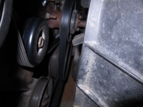 1991 Ford LTD Crown Victoria - Close-up view of an engine's belt and pulley system, with some text visible on a plastic component.