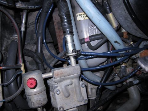 1991 Ford LTD Crown Victoria - Close-up view of engine parts, including a Ford-branded component with a firing order label.
