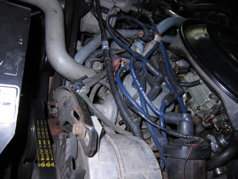1991 Ford LTD Crown Victoria - Close-up view of a vehicle's engine bay, showing various components like the carburetor and spark plug wires.