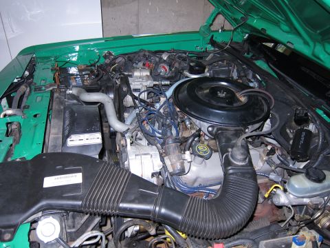 1991 Ford LTD Crown Victoria - The engine compartment of a car, showing various mechanical components and wiring.
