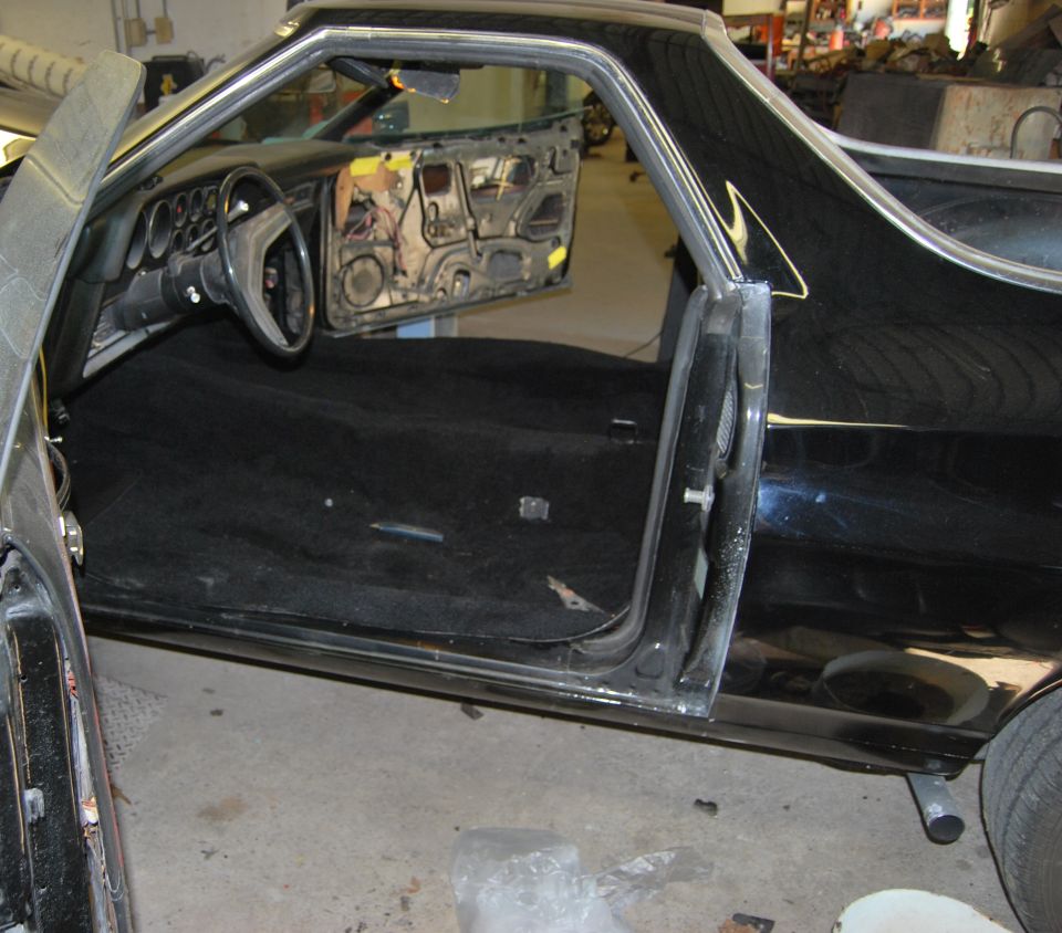 1975 Ford Ranchero interior with doors removed, black carpet, and dashboard