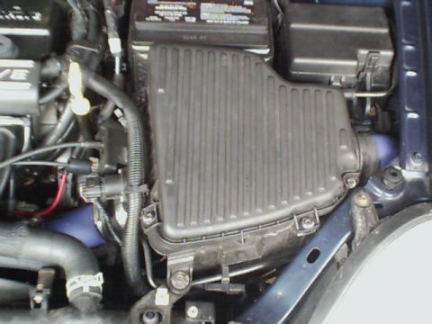 2000 Dodge Neon - Close-up view of a car's engine bay, showing the air filter assembly and battery.