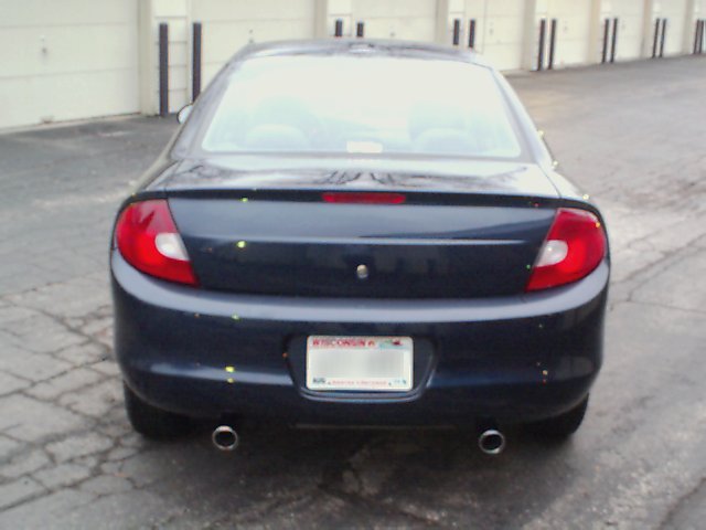 Dark blue sedan rear view, showing taillights, dual exhaust, and Wisconsin license plate