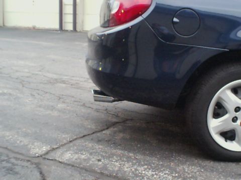 2000 Dodge Neon - Close-up of a car's rear section, showing the taillight and exhaust pipe.