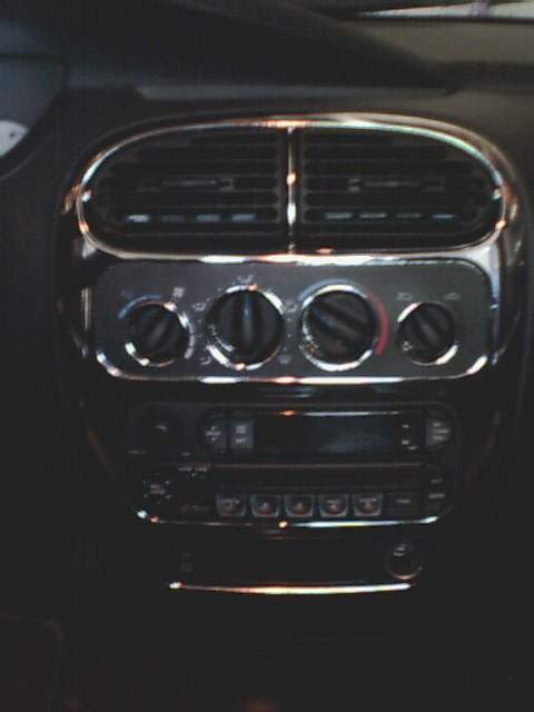2000 Dodge Neon - Interior view of a car's dashboard, showing air vents and radio controls with chrome accents.