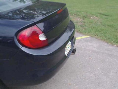 2000 Dodge Neon - Rear view of a dark blue sedan, likely a 2000 Dodge Neon, showing its taillight and trunk spoiler.