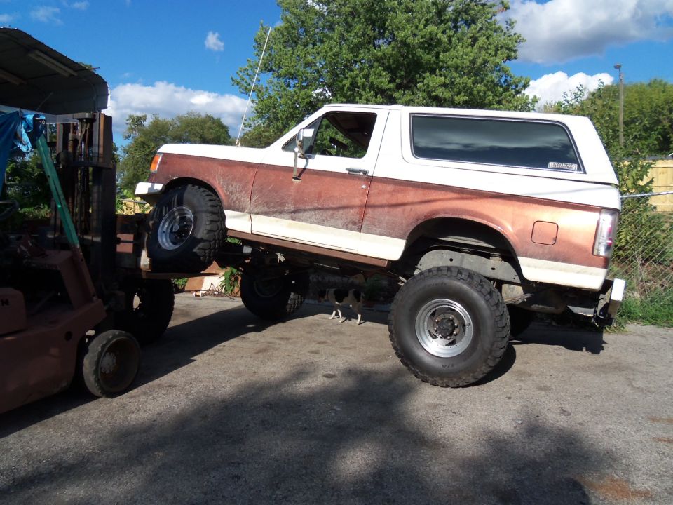 1989 Ford Bronco lifted by forklift, side view