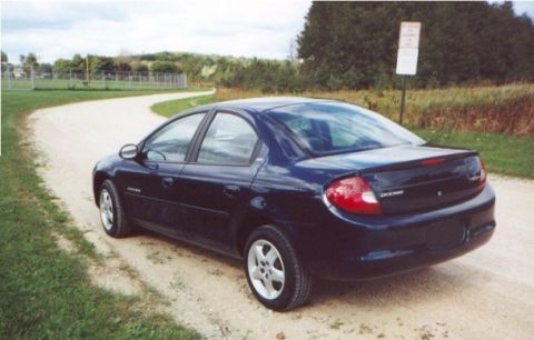 2000 Dodge Neon - Dark blue 2000 Dodge Neon sedan seen from the rear on a dirt road.