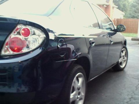 2000 Dodge Neon - Rear quarter panel view of a dark blue sedan, identified as a 2000 Dodge Neon.