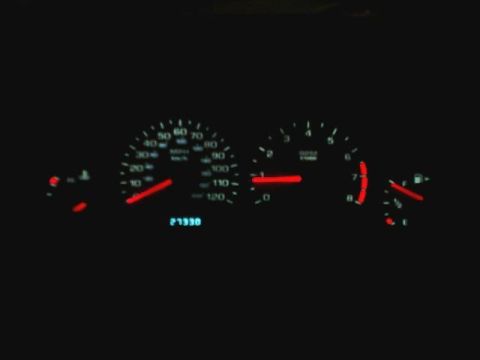 2000 Dodge Neon - Dashboard gauges display speed, RPM, and fuel level in a dark interior.