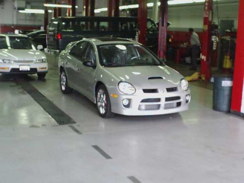 2000 Dodge Neon - A silver Dodge Neon SRT-4 is parked in a garage, with another car visible to its left.