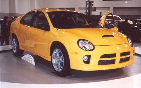 2000 Dodge Neon - A yellow Dodge Neon SRT-4 is displayed with its driver's door open, its sporty design.