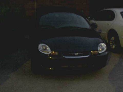 2000 Dodge Neon - A black 2000 Dodge Neon is parked in front of a white car, with visible SuperMotors.net branding at the bottom right.