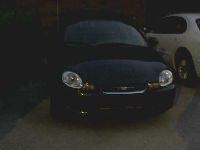Front view of a black 2000 Dodge Neon with a white car behind it