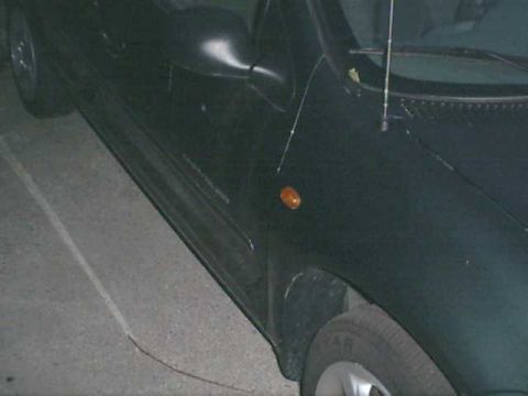 2000 Dodge Neon - The side profile of a dark vehicle is captured in this photograph.