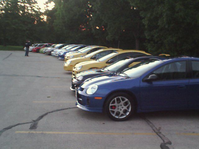 Blue Dodge Neon SRT-4 parked in a lot, front 3/4 view. Red brake calipers visible