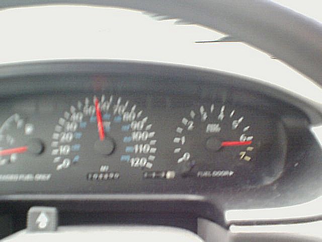 Dashboard gauges showing speed and RPM, with odometer reading 104499
