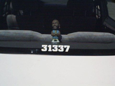 1995 Plymouth Neon - A dashboard bobblehead sits above a plate with the number "31337".