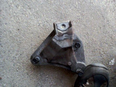 1995 Plymouth Neon - A metal engine mount bracket with bolts is shown against a concrete background.