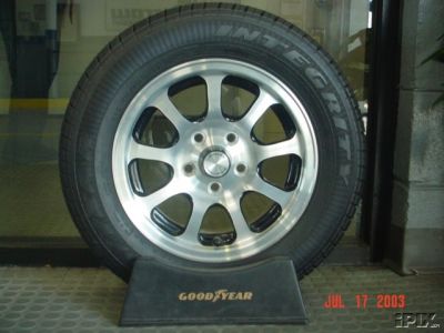 1995 Plymouth Neon - A tire and wheel assembly is displayed on a stand, with visible branding for Goodyear and Supermotors.