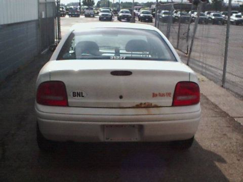 1995 Plymouth Neon - White sedan parked outdoors with a BNL sticker and rust on the rear bumper.
