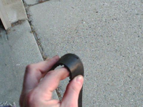 1995 Plymouth Neon - A hand holds a black plastic automotive part, with 'SUPERMOTORS' visible in the lower right corner.